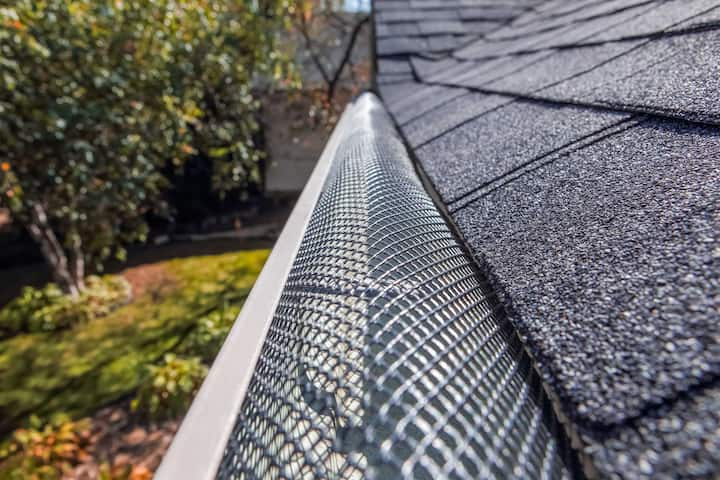 A contractor demonstrating the effectiveness of a gutter guard to a potential client in Des Moines